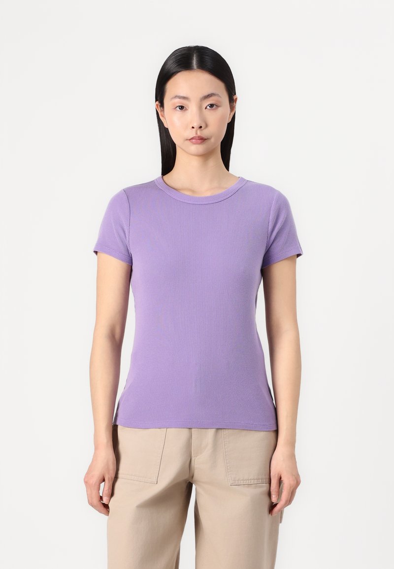 T-shirt corti a maniche con righe lilla, con scollatura rotonda, design aderente e texture senza cuciture, abbinato a pantaloni beige a vestibilità ampia.