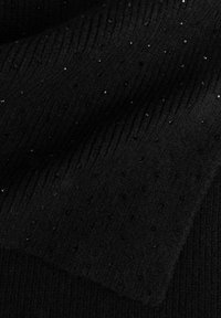Tessuto di maglia nera con un design testurizzato che presenta coste verticali e piccoli accenti di perline sparse per un dettaglio sottile.