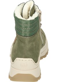 Bottine verte avec des matériaux en cuir et en tissu, doublure moelleuse, fermeture éclair latérale et semelle en caoutchouc texturé beige.