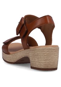 Brown leather sandal with a wide strap, adjustable buckle, and a textured light-brown platform heel. Open back design.
