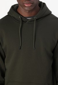 Dark green hoodie made of soft fabric, featuring a drawstring hood, front pocket, and ribbed neckline. Smooth texture with no patterns.