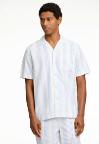 Camisa de botones de manga corta en patrón a rayas en azul claro y blanco, hecha de una tela suave, con un bolsillo en el pecho y corte relajado.