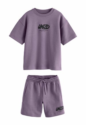 Lila kurzärmeliges Hemd und passende Shorts mit schwarzem "UNLTD"-Text und London-Koordinaten, die auf beiden Teilen gedruckt sind.