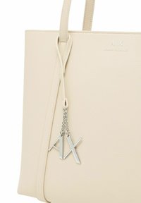 Borsa tote beige con texture realizzata in pelle, dotata di due manici e di un accento in catena argentata con le iniziali del marchio "A/X" attaccate.