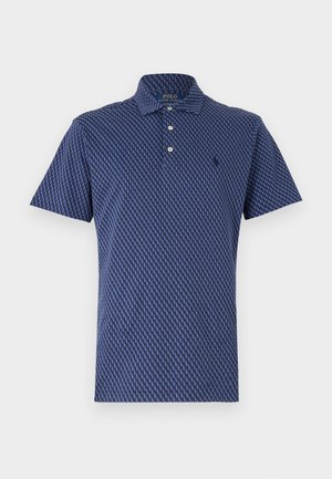 Sötétkék polo póló, textúrált geometrikus mintával. Klasszikus gallérral és három gombos nyakkal rendelkezik. Kicsi logó a mellkason.