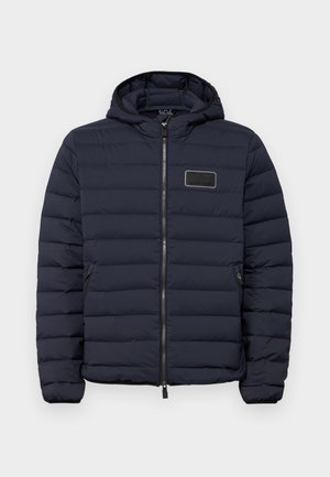 Giacca imbottita blu navy con cappuccio, con cerniera frontale, motivo trapuntato orizzontale e una toppa logo rettangolare sul petto.