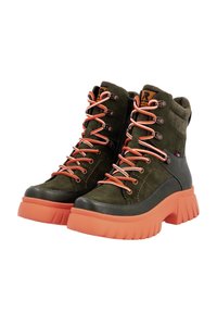 Bottes chelsea en suedine verte et cuir avec des lacets orange, semelle en caoutchouc et accents gris. Semelle épaisse notable avec une surface texturée antidérapante.