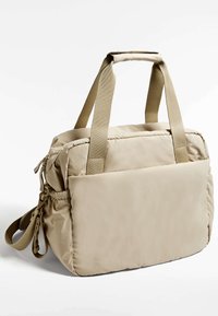 Borsa beige a soffietto con due manici superiori, una tracolla rimovibile e chiusura a zip. Caratterizzata da una texture liscia e una costruzione imbottita.