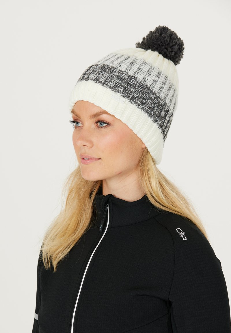 Stickad mössa i krämfärgad och grå med randig mönstring och en mörk pom-pom. Har en ribbad mudd och en logotagg. Mjuk, texturerad material.