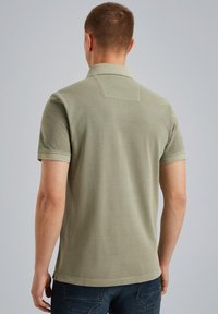 Polo shirt à manches courtes pour homme en vert olive, avec un col, un ourlet droit et une texture douce avec peu de détails à l'arrière.