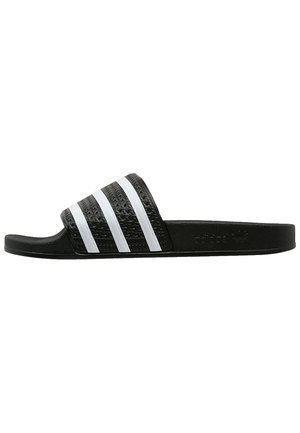 Zwarte Adidas slide-sandaal met een gestructureerde band met drie witte strepen en platte zool, zijaanzicht.