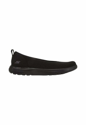 Scarpa nera slip-on con suola flessibile e piccola linguetta sul tallone, con logo Skechers sul lato.