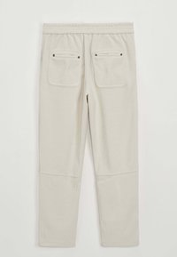 Pyjama gris clair en tissu côtelé. Comprend une taille élastique et deux poches arrière avec boutons-pression. Design à jambes droites.