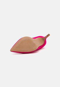 Chaussure pointue en daim rose avec un talon fin et une semelle extérieure beige lisse. Design minimaliste avec une texture douce et sans matériel visible.
