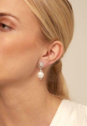 Boucles d'oreilles en argent avec une perle ronde pendante. Le design comprend un clou circulaire texturé et une perle sphérique lisse suspendue en dessous.
