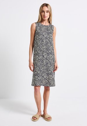 Sleeveless dress with a navy and cream zebra print in a geometric pattern. Soft, lightweight fabric; knee-length design; no visible hardware.