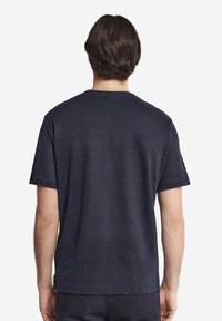 Marinblå kortärmad T-shirt i mjuk bomull. Har en rund halsringning och en avslappnad passform. Strukturerad tyg med subtila variationer.