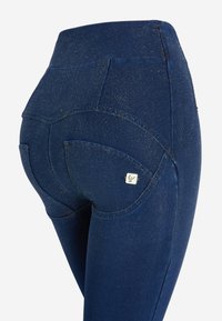 Leggings glitterati blu navy con tasche posteriori curve e vita alta, realizzati in tessuto elasticizzato con una superficie liscia.