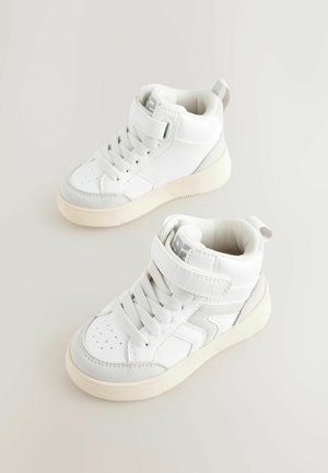 Bílé vysoké tenisky s texturovaným svrškem, zavazováním na tkaničky a suchý zip, kulatá špička a jemné šedé akcenty na straně.