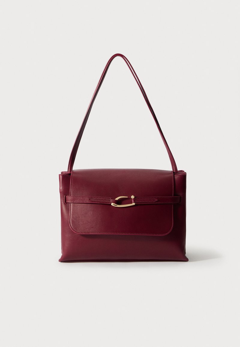 Burgundy nahkalaukku, jossa on jämäkkä muotoilu, litteä malli ja yksi olkahihna. Sisältää kultasävyisen yksityiskohdan ja sileän pinnan.
