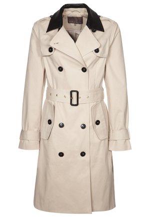 Beige kaksirivinen trenssitakki mustilla nappeilla, vyötäröllä vyö, musta kaulus ja liehukkeet kummallakin puolella.