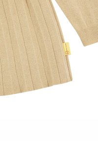 Beige pletený svetr s dlouhými rukávy, texturovanou látkou a malou žlutou cedulkou na postranním lemu.