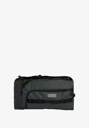 Grå duffel bag lavet af slidstærkt stof, med en lynlåslomme, justerbare stropper og en tekstureret sidepanel med ventilation.