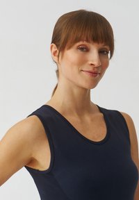 Marineblauw sporttanktop met een ronde hals en mouwloos ontwerp; heeft textuur details aan de zijkanten en een gladde stof.