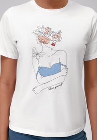 Bílý bavlněný tričko s potiskem ilustrace ženy s květinovými hlavovými dekoracemi, modrým topem, červenými rty a textem "Miluj sám sebe."
