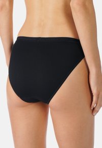 Czarne bawełniane majtki o gładkiej fakturze, z elastycznym pasem i wysokim wycięciem nogawek. Prosty design, bezszwowe brzegi dla wygody.
