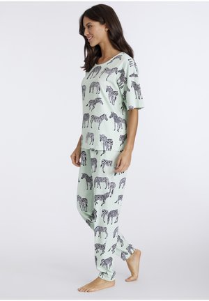 Conjunto de pijama verde claro con patrones de cebra negros, camisa de manga corta y pantalones a juego con puños elásticos. Tejido suave, corte relajado.