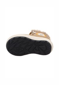 Schuhsohle mit einem schwarzen Gummiprofil, beigem, weichem Obermaterial, das ein dekoratives Patch und einen flauschigen Rand an der Seite aufweist.