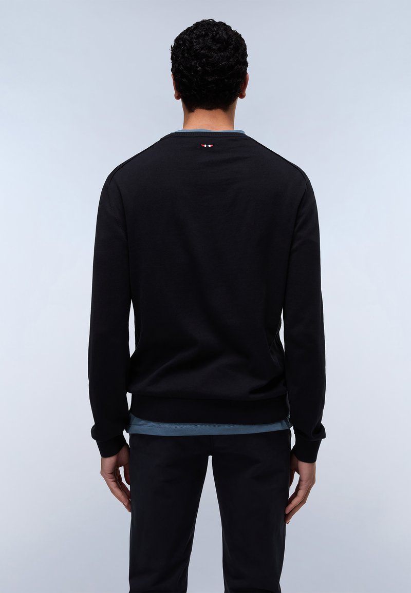 Felpa nera con polsini e orlo a coste, caratterizzata da uno strato interno blu visibile nella parte inferiore. Dettaglio logo rosso e bianco di piccole dimensioni al collo.