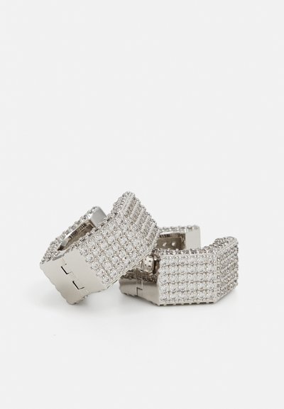 Silver hoop earrings with a rectangular shape, featuring a textured surface and covered in clear rhinestones for decoration.