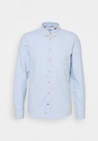 Camicia azzurro chiaro a maniche lunghe in lino, con colletto button-down e bottoni di legno lungo la parte anteriore e ai polsini.