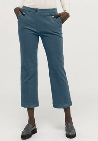 Blå kordflöjelbyxor med rak passform, kort längd, framfickor och en enda knappstängning. Strukturerad tyg med synliga ribbor.