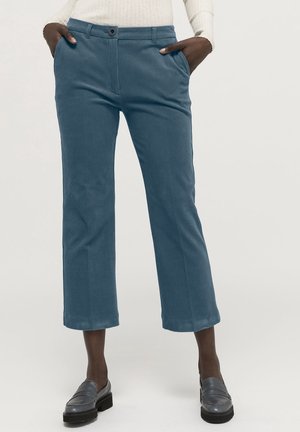 Pantalon en velours côtelé bleu avec une coupe droite, longueur raccourcie, poches avant et fermeture à un bouton. Tissu texturé avec des stries visibles.
