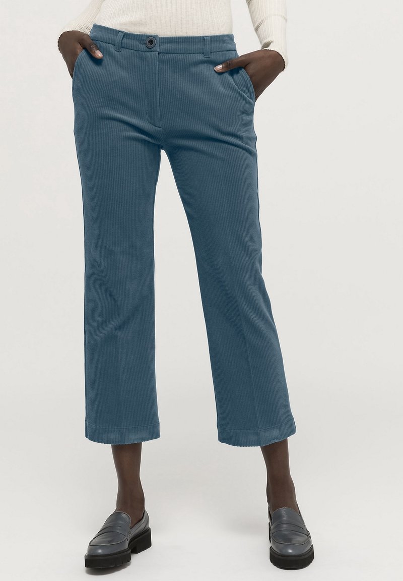 Blå kordflöjelbyxor med rak passform, kort längd, framfickor och en enda knappstängning. Strukturerad tyg med synliga ribbor.