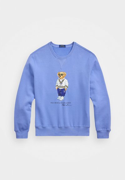 Blue sweatshirt featuring an embroidered bear wearing sunglasses and sports attire, with ribbed cuffs and hem, made from soft cotton fabric.