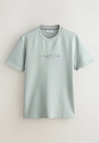 Camiseta verde claro de manga corta, con cuello redondo y texto bordado "Sorrento Nuevo Provincia Italia" en la parte delantera.