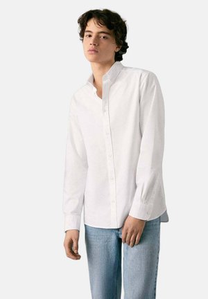 Weißes Hemd mit langen Ärmeln aus leichtem Stoff. Verfügt über einen klassischen Kragen und eine glatte Textur, getragen mit blauer Jeans.