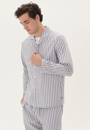 Gestreiftes Pyjama-Set in Weiß und Marineblau, bestehend aus einem knöpfbaren Oberteil mit Kragen und langen Ärmeln, kombiniert mit passenden, locker sitzenden Hosen.