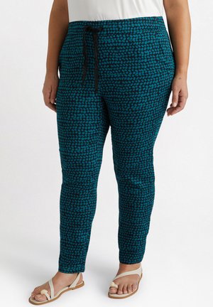 Blaue, gemusterte Hose mit weicher Textur, ausgestattet mit einem verstellbaren Bund undSlim-Fit, ergänzt durch geometrische Akzente.