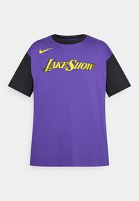 Tricou scurt cu mânecă, de culoare purpuriu, cu mâneci negre, având inscripția „LAKE SHOW” în text galben și un mic logo Nike pe umărul stâng.