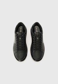 Sneaker in pelle nera con finitura liscia, punta rotonda, laccio frontale e colletto imbottito. Presenta un logo sulla linguetta.