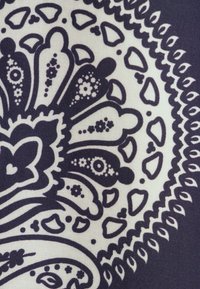 Tessuto blu navy e crema con intricate fantasie floreali e paisley, con forme diverse tra cui cuori e gocce, e una texture liscia.