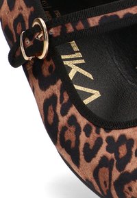 Bailarina de charol con estampado de leopardo, parte superior de tela, ribete negro, hebilla dorada y plantilla negra con logo en relieve.