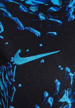 Nike-kläder med ett svart tyg med ett blått abstrakt mönster, som framhäver en kontrasterande blå broderad logotyp. Mjuk textur.