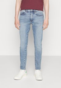 Ljust blå skinny jeans i denim med en klassisk fem-ficksdesign och svag urtvättning. Matchas med vita sneakers.