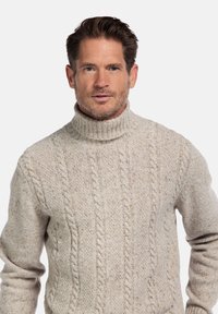 Beige kabelgebreide coltrui met geribbelde kraag en een textuurpatroon, gemaakt van een zachte, dikke wolmix.